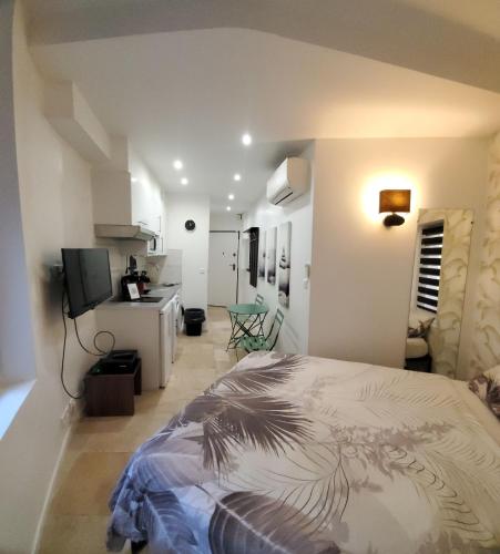 Cet appartement comprend une chambre avec un lit et une chambre avec une cuisine. dans l'établissement STUDIO CENTRE CANNES FORVILLE, à Cannes