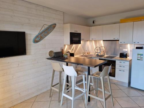a kitchen with a table and chairs and a refrigerator at Nidu Di Lume, Charmant T3, 2 chambres, vue mer in Algajola