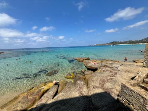 a group of people in the water at a beach at Nidu Di Lume, Charmant T3, 2 chambres, vue mer in Algajola