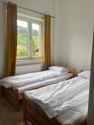 two beds in a room with a window at Willa Dolce Vita in Szczyrk