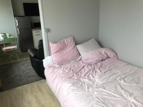 - un lit non aménagé dans une chambre avec une chaise dans l'établissement cocon marin, à Dieppe