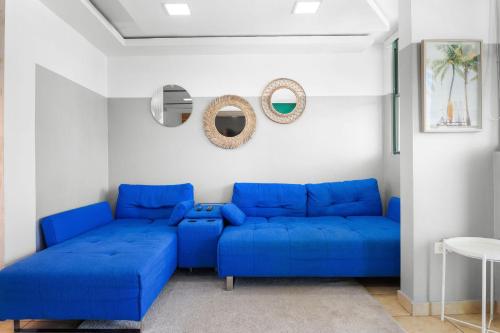 a blue couch in a white living room at Paradise at Aquatika Poolfront with Private Beach in Vieques