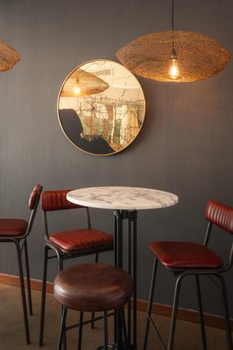 a table and four chairs in a room with a mirror at Frontier Hotel Rivera in Rivera