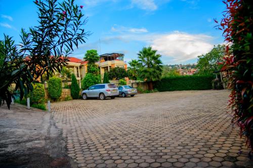 two cars parked in a driveway in front of a house at Quality Inn Hotel Kigali in Kigali