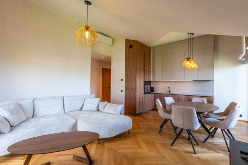 a living room with a white couch and a table at Heven Apartments Karusselli in Pärnu