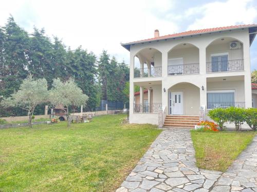 a large white house with a grass yard at Poseidon Horizon in Leptokaria