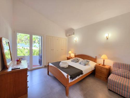 een slaapkamer met een bed, een bank en een raam bij Villa Alprochinhos in Porches