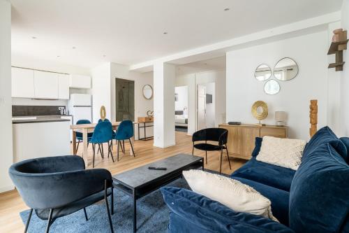 un salon avec un canapé bleu et des chaises dans l'établissement Superbe Appartement Moderne, Prado,à Deux Pas du Vélodrome, à Marseille