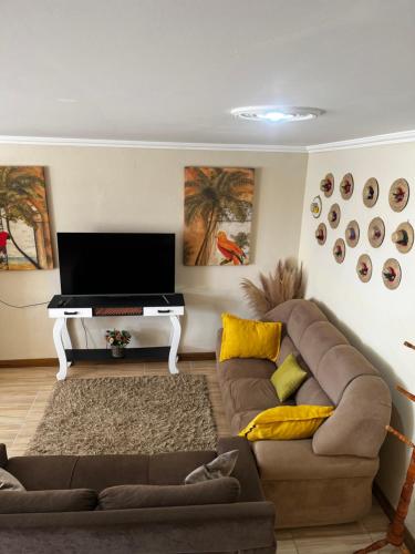 a living room with a couch and a piano at Recanto das Corujas in Campos do Jordão