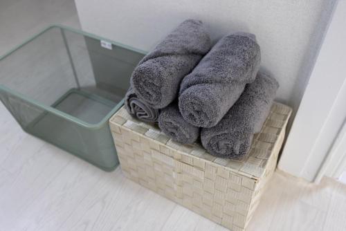 un cesto pieno di asciugamani e una scatola di vetro di Big Star Stay a Busan
