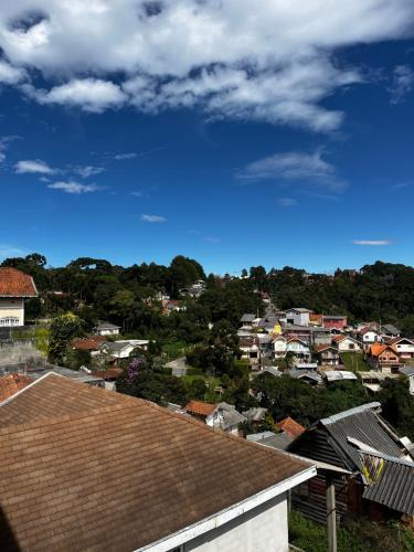 a view of a city with houses and roofs at Recanto das Corujas in Campos do Jordão