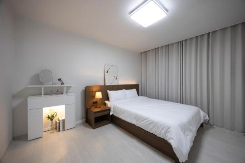 una camera bianca con letto e camino di Big Star Stay a Busan