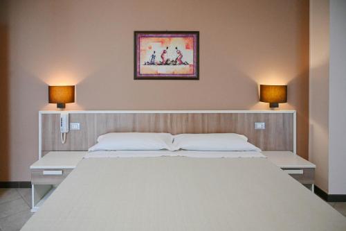a bedroom with a large white bed with two lamps at Stella del Sud in Avola