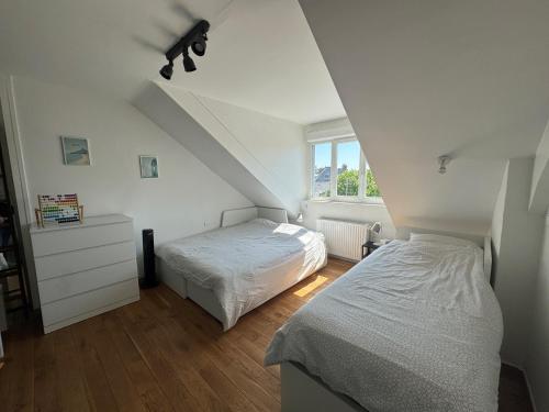 Un dormitorio con dos camas y una ventana. en Sunset Dieppe, en Dieppe