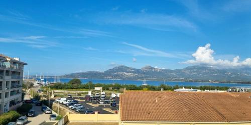 Elle offre une vue sur un parking avec des montagnes et un lac. dans l'établissement Sea view, balcony, private parking, à Calvi