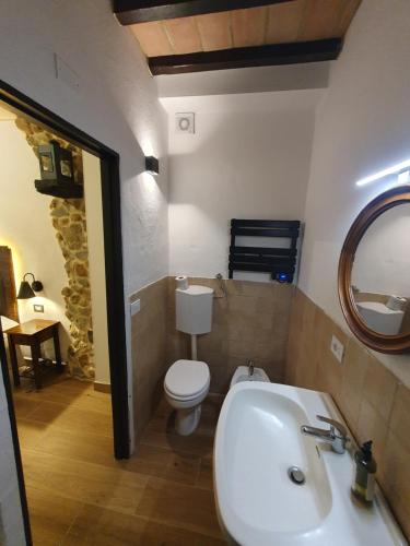 a bathroom with a sink and a toilet and a mirror at L'Alberghetto Le Dimore Di Contrasti in Castiglione dʼOrcia