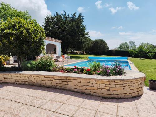 un mur de soutènement en pierre autour d'une piscine avec un jardin de soutènement dans l'établissement Number9 Studio - Now with air conditioning, à Carlipa