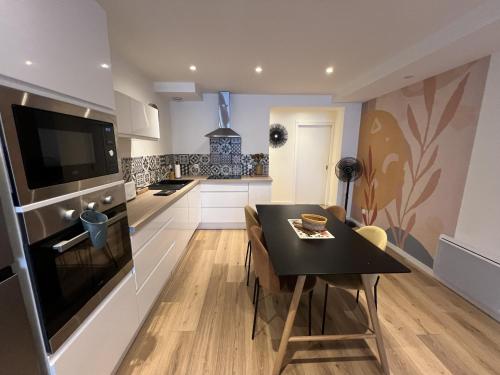 une cuisine et une salle à manger avec une table et un réfrigérateur dans l'établissement Le Val De Coeur, à Valence