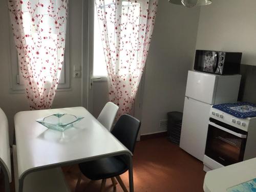 une petite cuisine avec une table blanche et une fenêtre dans l'établissement Sara's Home 24, à Rouen