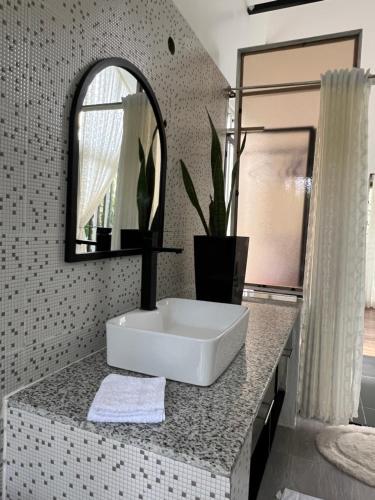 a bathroom with a white sink and a mirror at Twenty ritz cottage in Migori