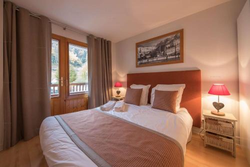 une chambre avec un grand lit et une fenêtre dans l'établissement Savoielac - La Clusaz - Pied des pistes : Appartement Primevères, à La Clusaz