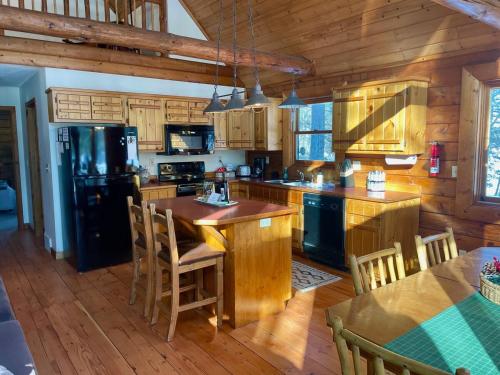 a kitchen with a black refrigerator and wooden cabinets at The Hideaway on Clear Lake Island in Hayward