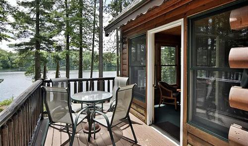 a patio with a table and chairs on a deck at The Hideaway on Clear Lake Island in Hayward