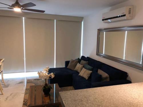 a living room with a blue couch and a fan at Aria Ocean Rentals - Riviera Nayarit in Nuevo Vallarta 