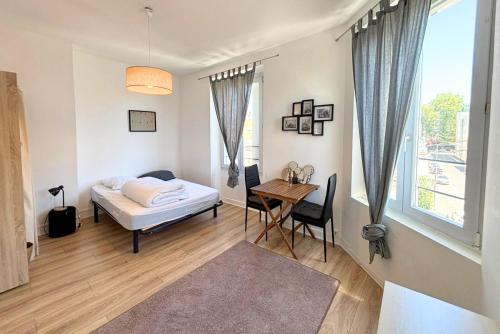 une chambre avec un lit, une table et une fenêtre dans l'établissement Appartement cosy à deux pas de la cathédrale, à Reims