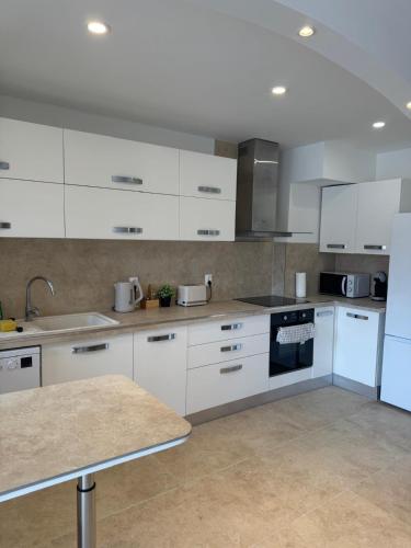 a kitchen with white cabinets and a stove top oven at Magnifique T2 avec grande terrasse in Le Cannet