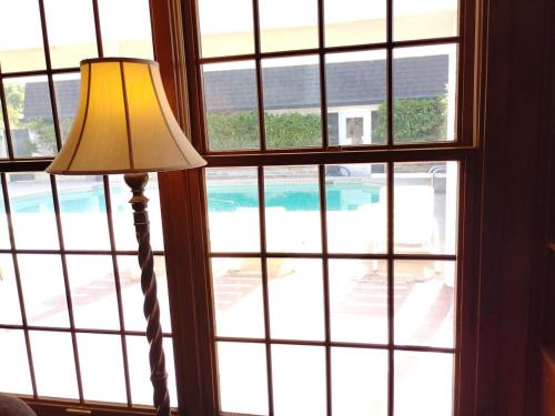 Una lámpara delante de una ventana con vista a una piscina. en Massive 4 Bedroom House with Pool, en Oroville