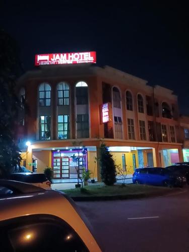 a man hotel with a neon sign in front of it at JAM Hotel Kota Warisan Sepang @ ERL Salak Tinggi, KLIA 1-2 & F1 in Sepang