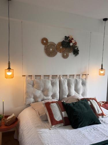 une chambre avec un grand lit blanc avec des oreillers dans l'établissement L'écrin de la villa des roses, à Pontmain