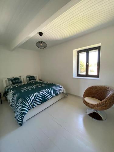 une chambre avec un lit, une fenêtre et une chaise dans l'établissement DOMAINE LA MASQUIERETTE, à Villepinte