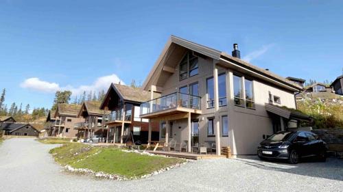 a large house with a car parked in the driveway at Cabin at Norefjell! Perfect for families with children in Runn