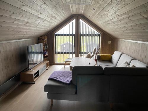 a living room with a couch and a tv at Cabin at Norefjell! Perfect for families with children in Runn