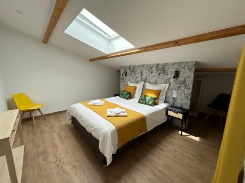 une chambre avec un grand lit avec une couverture jaune dans l'établissement Le Christolive Saint Victor la Coste, à Saint-Victor-la-Coste
