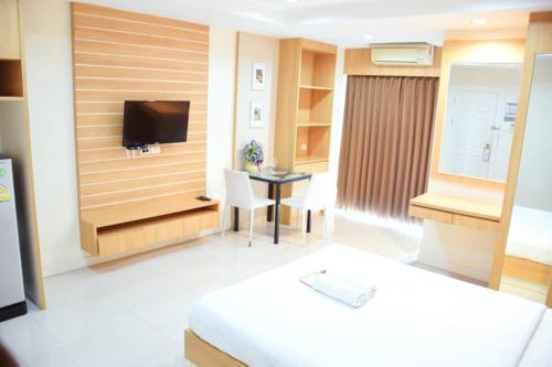a hotel room with a bed and a tv at Sea Hill Hotel Bangsaray in Bang Sare