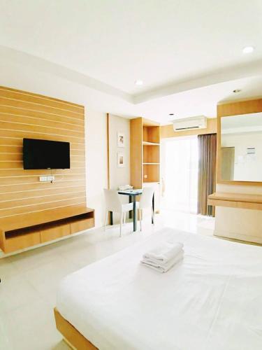 a hotel room with a bed and a flat screen tv at Sea Hill Hotel Bangsaray in Bang Sare
