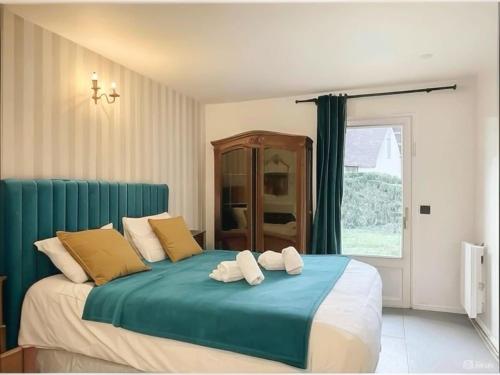 une chambre avec un lit avec deux serviettes dessus dans l'établissement Charmante maison, 8 personnes, piscine et tennis, à Deauville