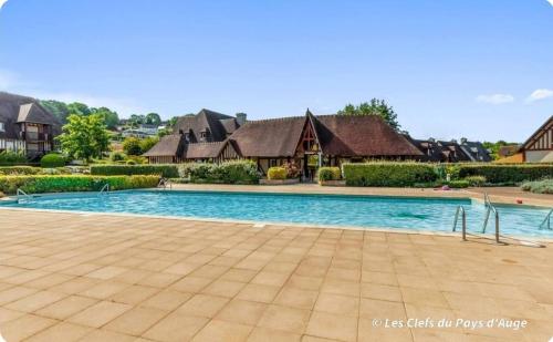 une piscine devant une maison dans l'établissement Charmante maison, 8 personnes, piscine et tennis, à Deauville
