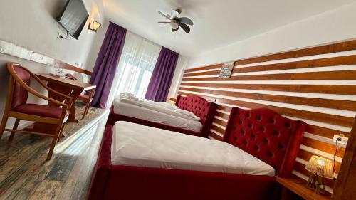 a room with a bed and a table and a desk at Cabana Sura Getilor Arinis in Voronet