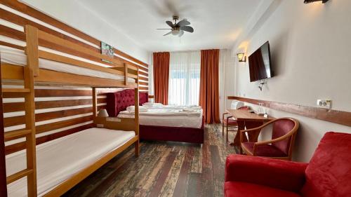 a hotel room with a bunk bed and a desk at Cabana Sura Getilor Arinis in Voronet