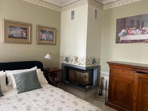 a bedroom with a bed with a fireplace and a tv at Stanze Degli Aceri in Murazzano