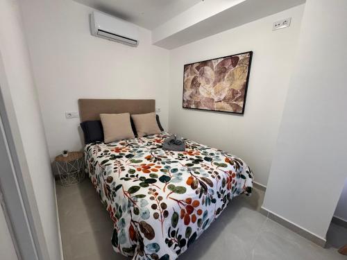 a bedroom with a bed with a floral comforter at Apartamento Kenia Tranquilo, acogedor y céntrico in Almansa