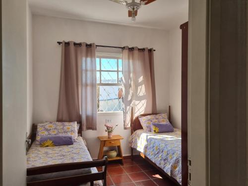 a bedroom with two beds and a window at Casa - Águas de São Pedro in Águas de São Pedro