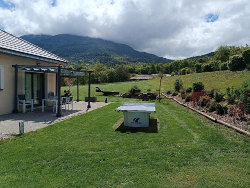 - une table de pique-nique dans l'herbe à côté d'une maison dans l'établissement Magnifique Villa Sabot de Venus, à Le Lautaret