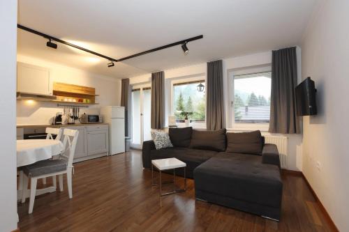 a living room with a couch and a table at Vila Edelweiss Rooms&App Kranjska Gora in Kranjska Gora