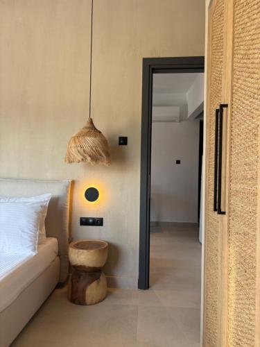 - une chambre avec un lit et un tabouret à côté d'une table dans l'établissement Yannos 1930, à Nea Iraklitsa