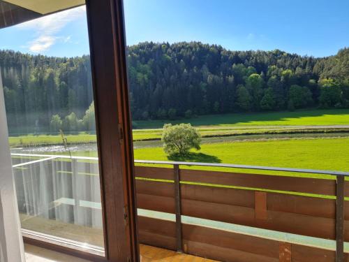 a window with a view of a green field at Waldpension Rabeneck in Waischenfeld